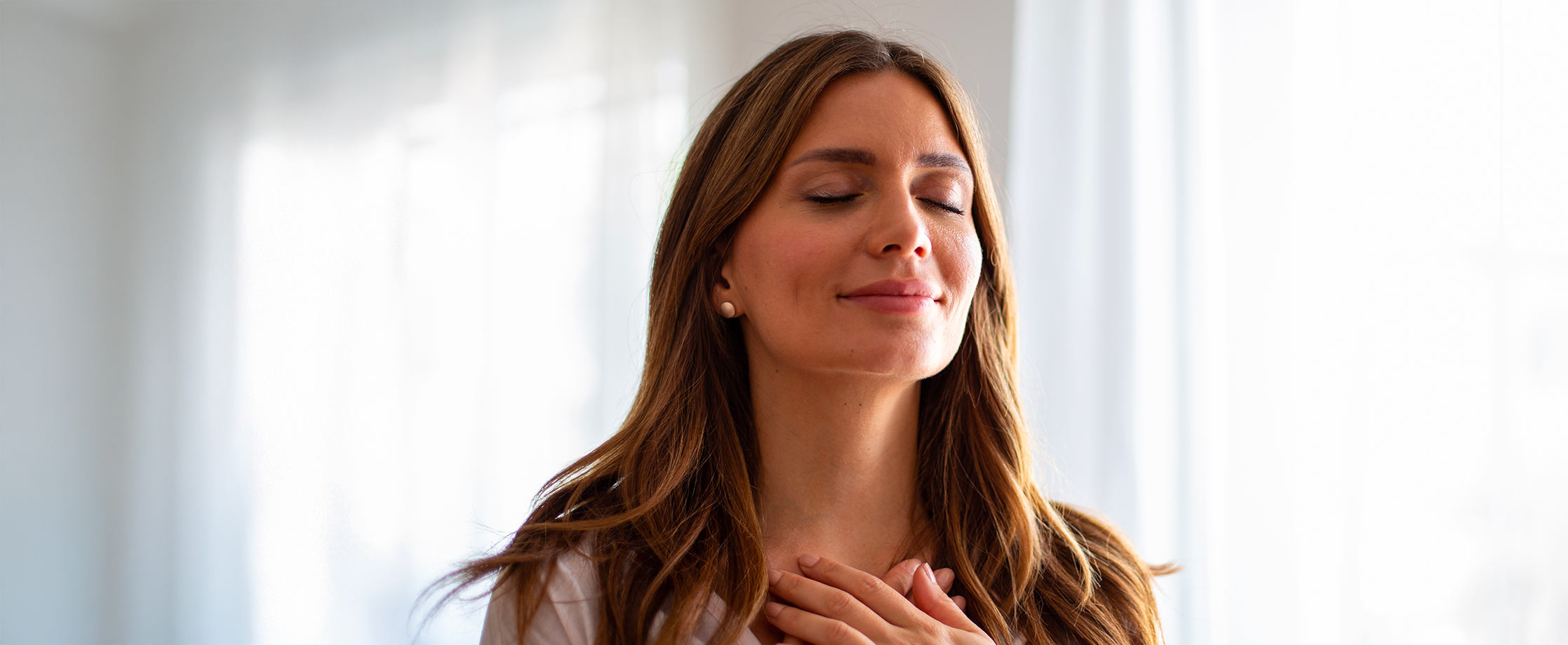 Femme pratiquant un exercice de respiration les yeux fermes